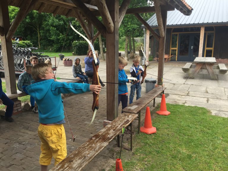 Kinderen schieten pijl en boog op een kinderfeestje in Groningen